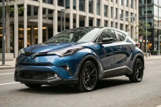 Toyota C-HR compact SUV garé en ville, vue 3/4 avant mettant en valeur sa longueur et ses lignes sculptées