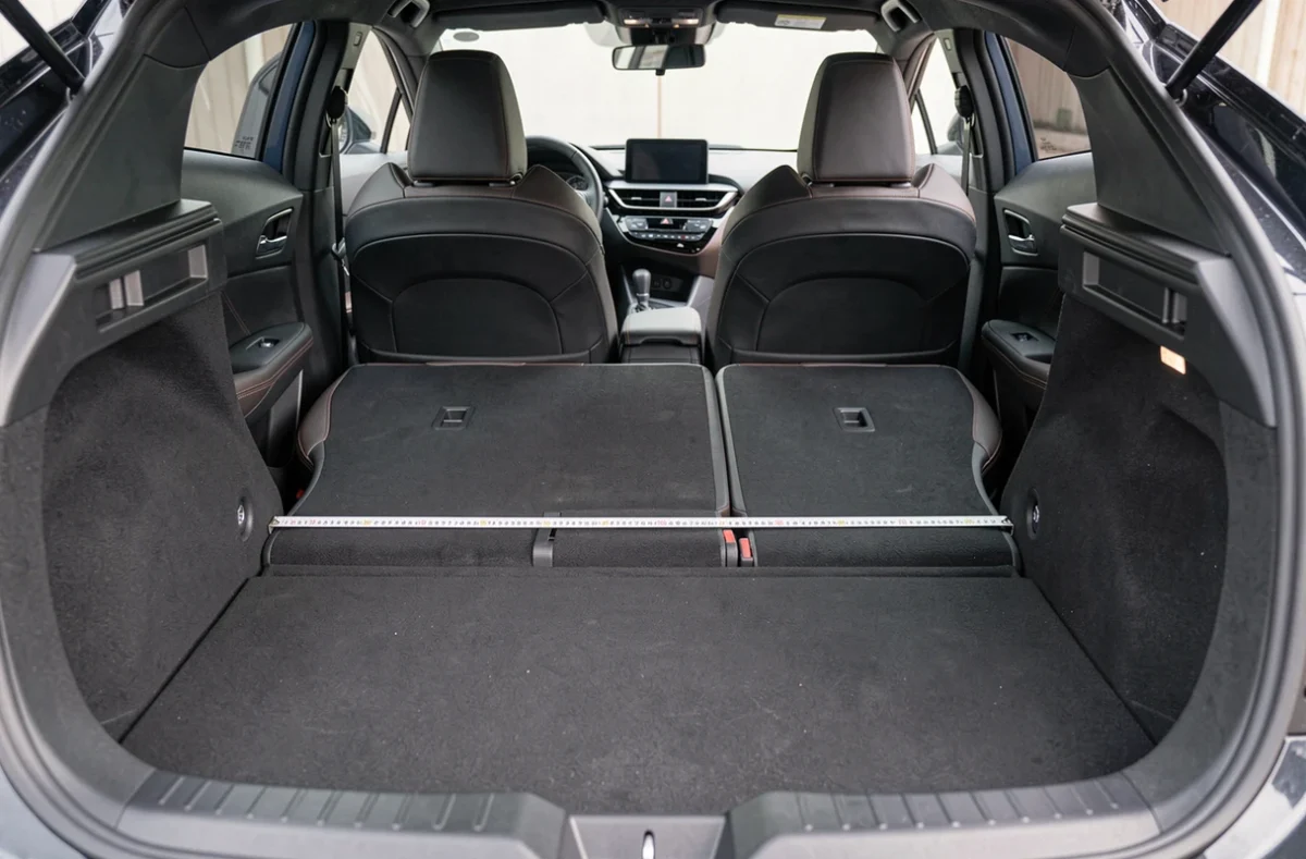 Intérieur et coffre du Toyota C-HR avec mètre ruban illustrant le volume utile et la largeur de l'habitacle